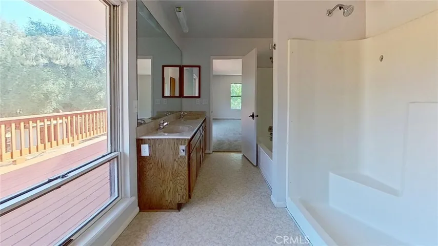 master bath has two showers and one tub as well as a double sink vanity