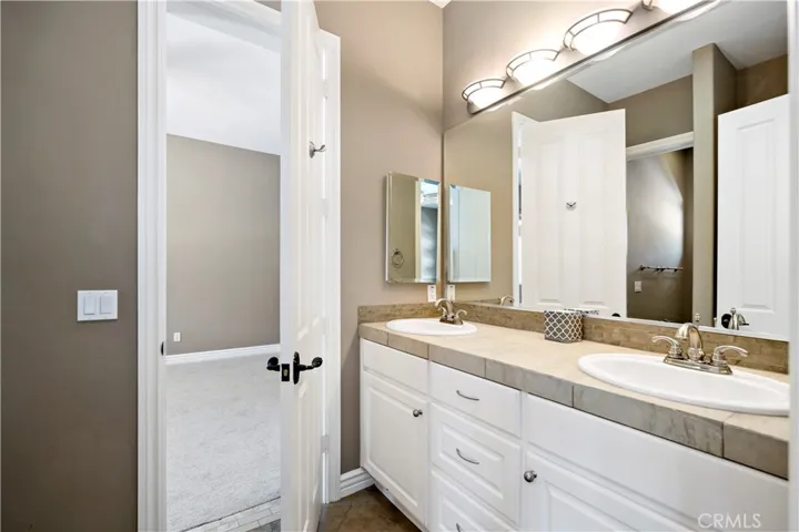 Jack 'n' jill bathroom w dual sinks and tub/shower thru doorway in the mirror that serves bedrooms #2 & #3