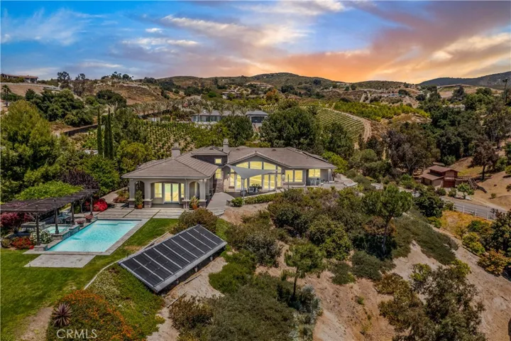 Twilight aerial of pool area and back of home