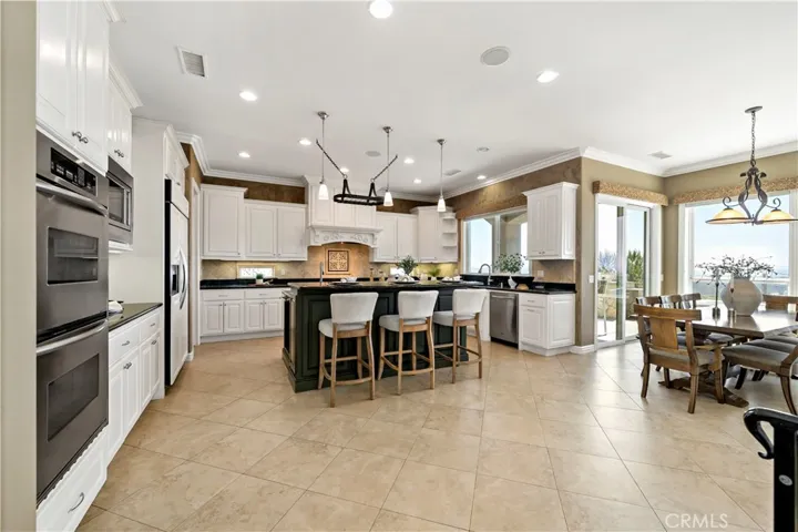 Kitchen w informal dining area to the right and sliding doors to another patio area