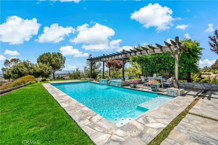Pool and raised spa w patio seating area and panoramic valley views