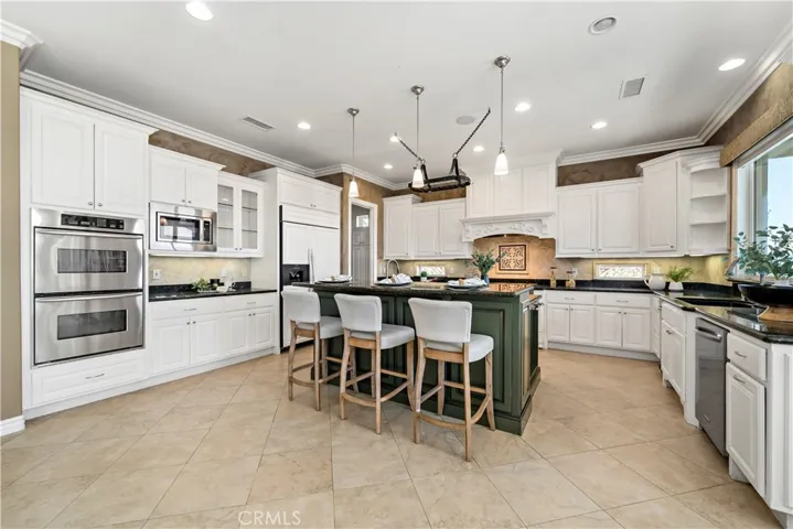 Kitchen featuring dual ovens and pendulum lighting