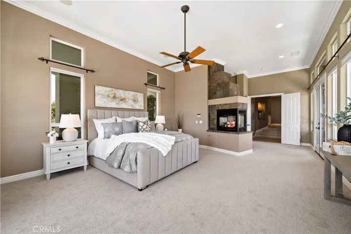 Reverse angle of primary bedroom w 2 sided fireplace at left
