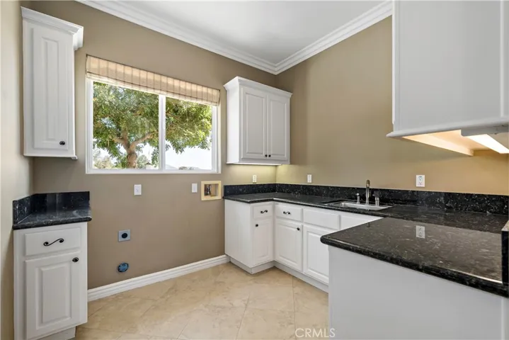 Laundry room w plenty of counter and cabinet space, sink and both gas and electric for dryer.