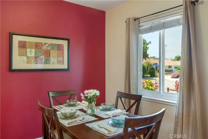Cozy dining area with accent wall and large window facing front yard.