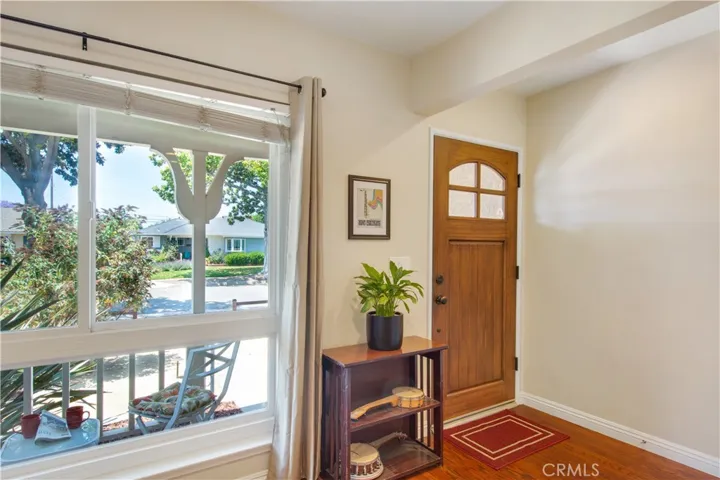 Living room facing large window, beautiful craftsman style front door and covered front porch patio.
