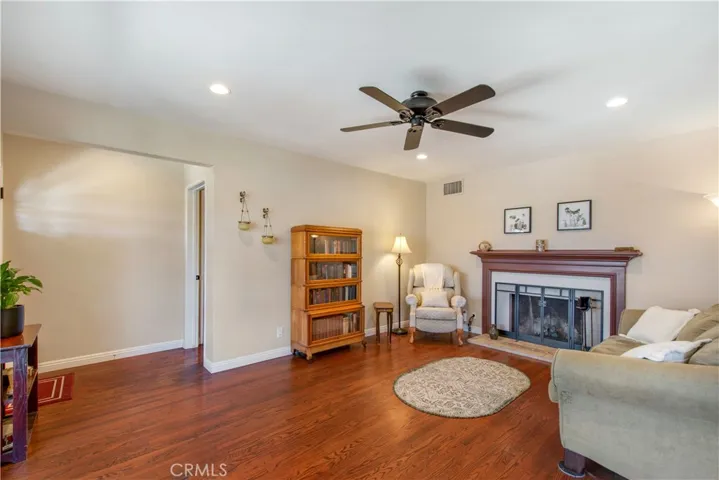 Spacious living room with wooden floors leading into front entry and bedrooms.