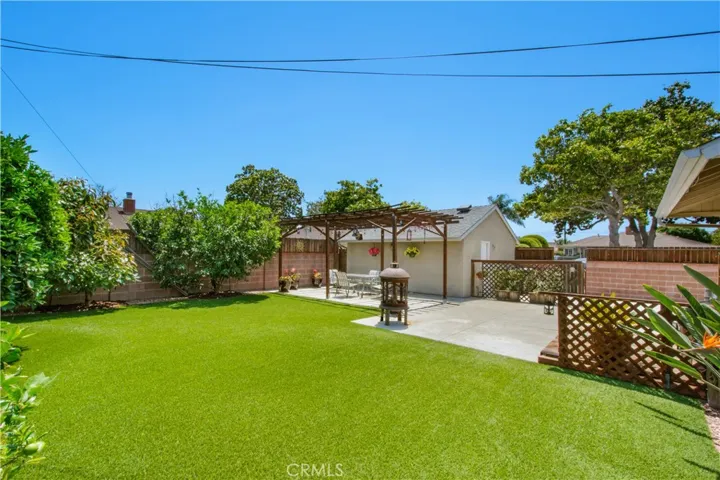 View of back yard artificial grass and fruit trees.