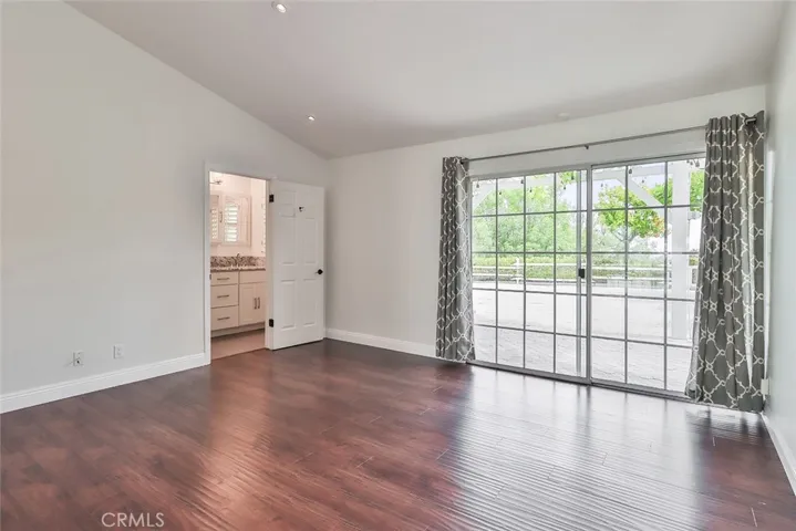 Primary bedroom has sliding doors to backyard