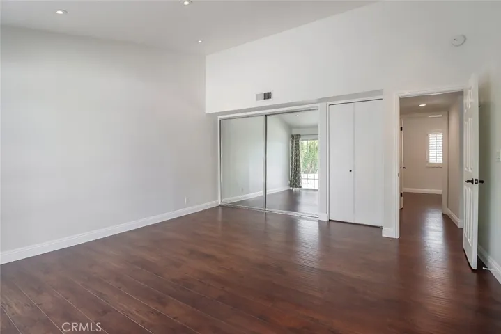 Primary bedroom has mirrored closets and an extra closet