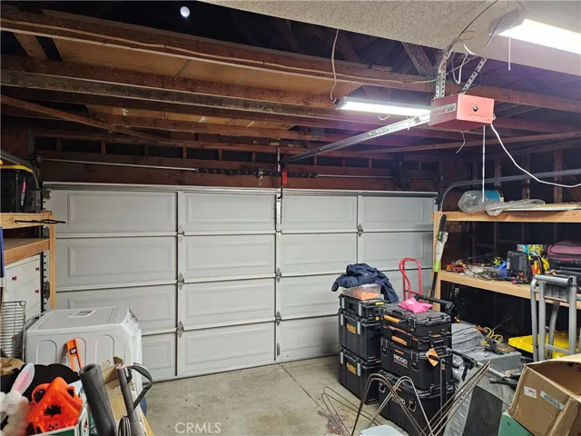 Nice sectional garage door with garage door opener. Seller will be leaving the wood shelves - they will hold a lot of storage.