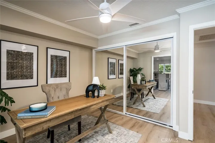 Office has mirrored closet doors and built in cabinets and shelves.