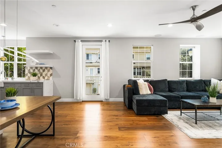 Light and Bright main living area with patio, hardwood floors,and ceiling fan.