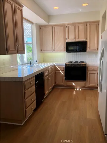 At opporsite side of Kitchen, are windows and space for Table & Chairs