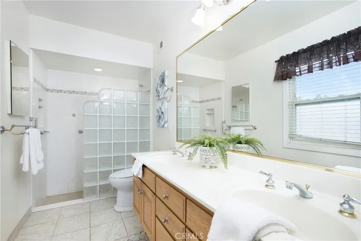 primary bath with shower and dual vanity