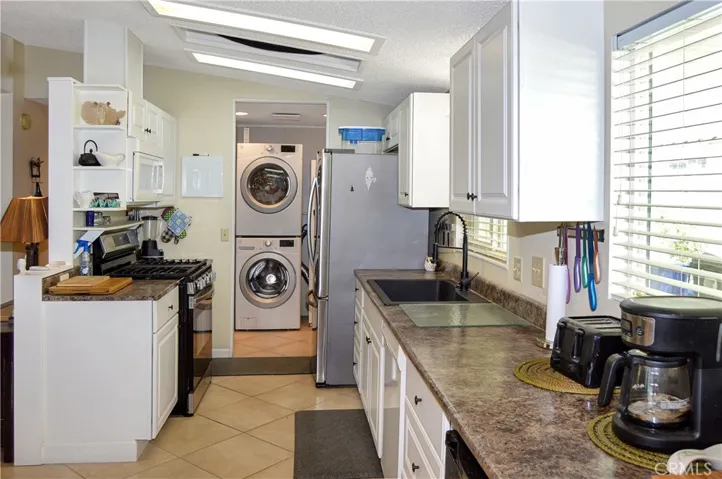 The updated kitchen offers stylish white cabinetry which extends into the dining area so there's plenty of prep and storage space, a new black granite sink & faucet, stainless steel range and fridge, dishwasher, microwave & tile floors
