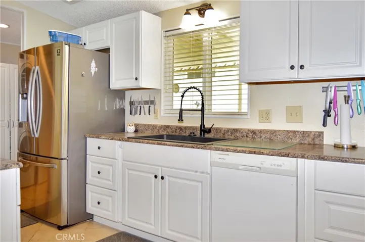 The updated kitchen offers stylish white cabinetry which extends into the dining area so there's plenty of prep and storage space, a new black granite sink & faucet, stainless steel range and fridge, dishwasher, microwave & tile floors