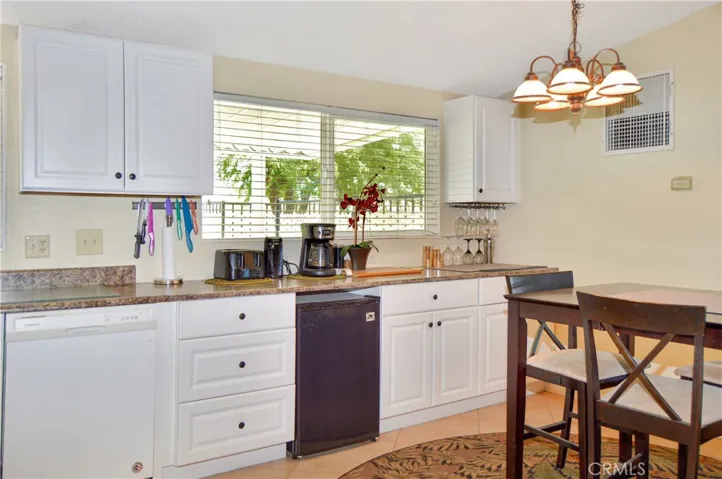 The updated kitchen offers stylish white cabinetry which extends into the dining area so there's plenty of prep and storage space, a new black granite sink & faucet, stainless steel range and fridge, dishwasher, microwave & tile floors