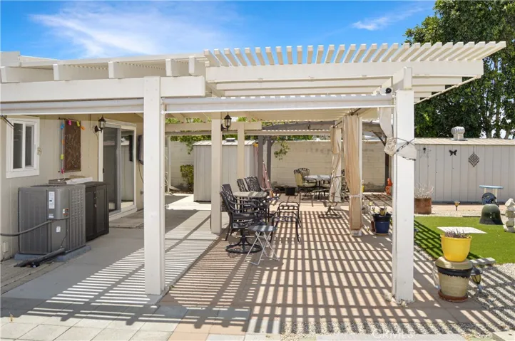 Back to that amazing backyard! Multiple covered patio provide the perfect spot to relax and enjoy the sweeping panoramic views of the desert landscape with distant mountains beyond with tall fences on both sides for privacy, artificial turf for your furry friends, easy-care rock scape, select greenery, and two large storage sheds which create a nook for the smaller patio