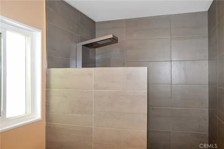 The main suite's bath has been upgraded with a custom, tiled, walk-in shower with a Vevor shower panel system with waterfall and massage jets