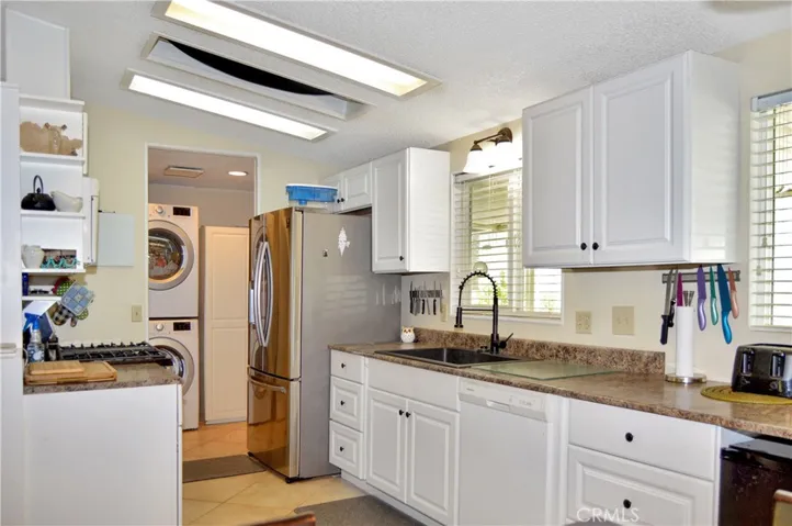 The updated kitchen offers stylish white cabinetry which extends into the dining area so there's plenty of prep and storage space, a new black granite sink & faucet, stainless steel range and fridge, dishwasher, microwave & tile floors