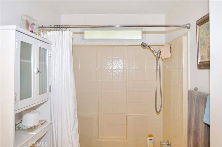 The 2nd bath has an attractive vanity, round mirror, and full-size tub/shower combo