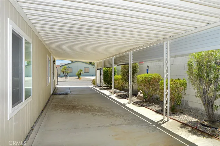 Front door side with awning and tall block wall fencing creating a nice, shady space along the whole side of the house with just enough greenery along the edge.