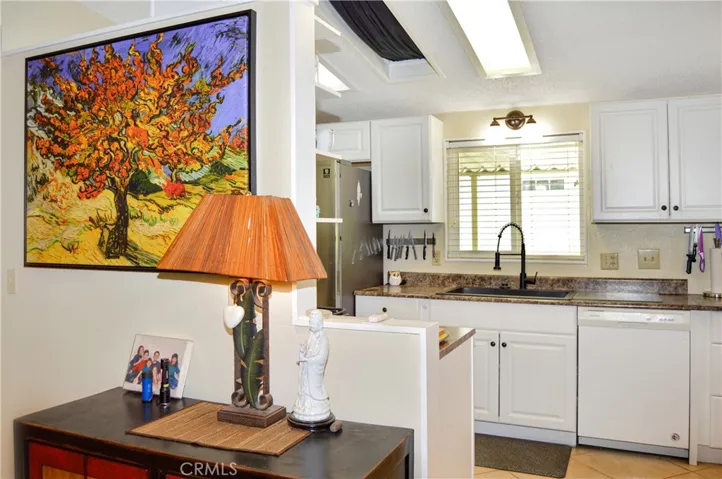 The updated kitchen offers stylish white cabinetry which extends into the dining area so there's plenty of prep and storage space, a new black granite sink & faucet, stainless steel range and fridge, dishwasher, microwave & tile floors