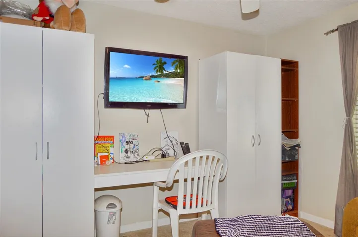 The 2nd bedroom is across from the main bedroom and offers a ceiling fan and mirrored wardrobe doors