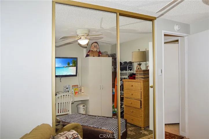 The 2nd bedroom is across from the main bedroom and offers a ceiling fan and mirrored wardrobe doors