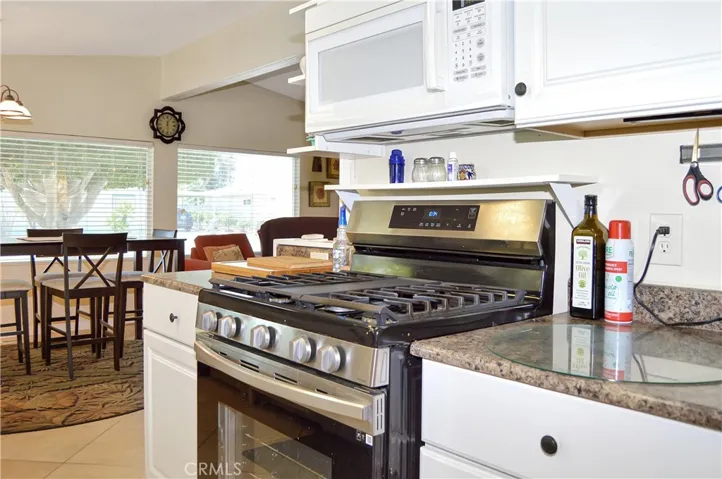 The updated kitchen offers stylish white cabinetry which extends into the dining area so there's plenty of prep and storage space, a new black granite sink & faucet, stainless steel range and fridge, dishwasher, microwave & tile floors