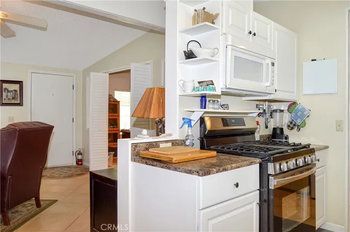 The updated kitchen offers stylish white cabinetry which extends into the dining area so there's plenty of prep and storage space, a new black granite sink & faucet, stainless steel range and fridge, dishwasher, microwave & tile floors