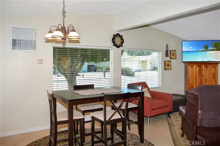 The dining area offers views of the front yard and neighborhood with extended kitchen cabinetry and a beverage fridge adjacent to it.