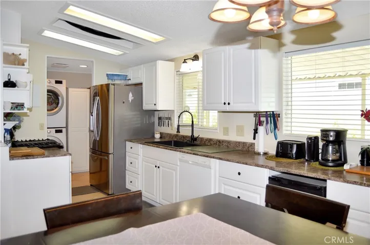 The updated kitchen offers stylish white cabinetry which extends into the dining area so there's plenty of prep and storage space, a new black granite sink & faucet, stainless steel range and fridge, dishwasher, microwave & tile floors