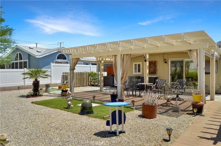 Back to that amazing backyard! Multiple covered patio provide the perfect spot to relax and enjoy the sweeping panoramic views of the desert landscape with distant mountains beyond with tall fences on both sides for privacy, artificial turf for your furry friends, easy-care rock scape, select greenery, and two large storage sheds which create a nook for the smaller patio