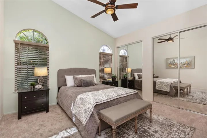 Primary Bedroom with Ceiling Fan and a Wall of Closets