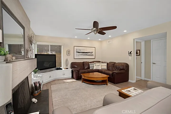 Family room with built in cabinets and newer flooring, recessed lighting and ceiling fan.
