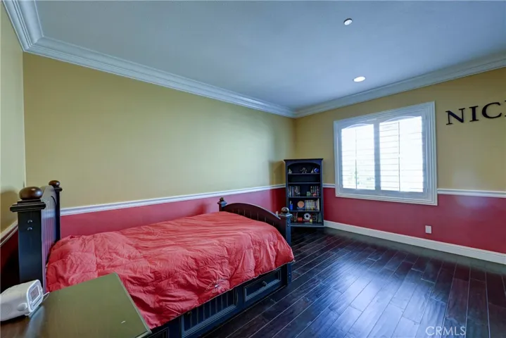 Upstairs ensuite  bedroom with rich hardwood type flooring.