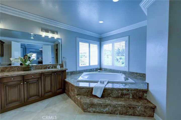 Primary bath with dual sinks and a jetted step up tub.