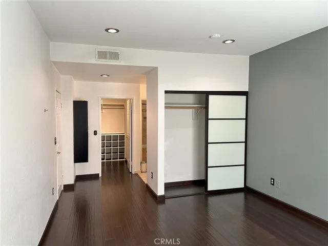 Primary bedroom which includes two closets with one being a walk-in with built-ins.