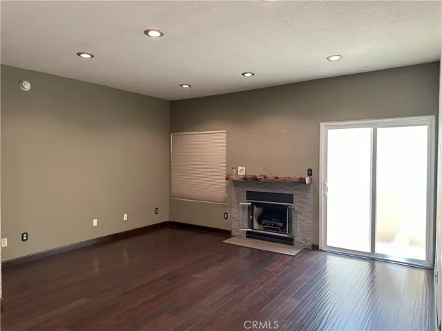 Living room with fireplace, sliding glass door to balcony.