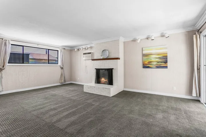Spacious living area with fireplace and sliding door to covered rear patio