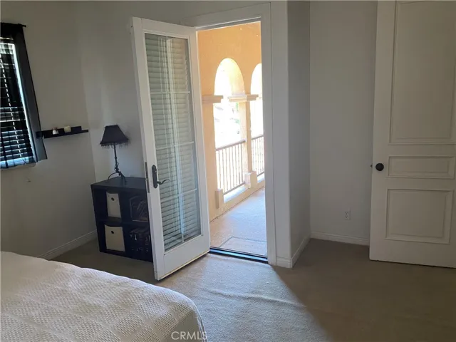 Upstairs bedroom with private balcony overlooking front of house with hills across