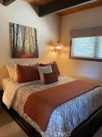 Main level bedroom with beamed ceiling
