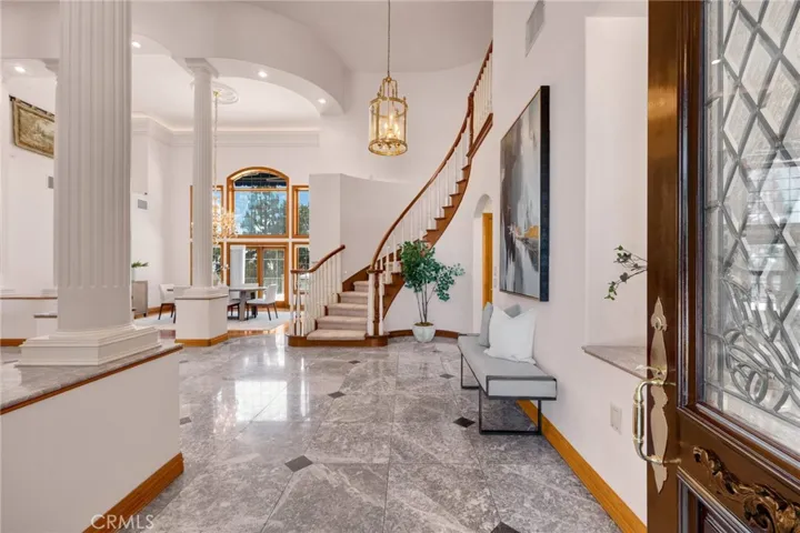 Entry into home with marble flooring and high ceilings.