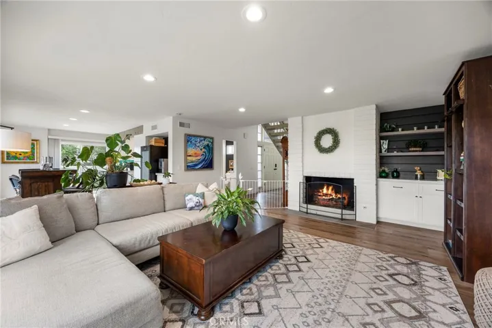 The living room which features a gas fireplace and built-in cabinets and shelves.