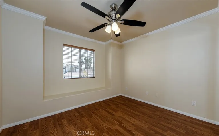 front bedroom with window seat, mirrored wardrobe doors and ceiling fan