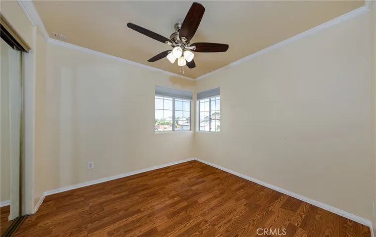 front corner bedroom with mirrored wardrobe doors & ceiling fan