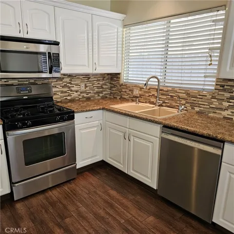 Kitchen with stainless steel appliances includes refrigerator