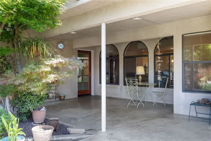 Backyard: large covered patio is north-facing so it is always shaded, ceiling lights, door to family room at rear, door to primary bedroom out of view at right.